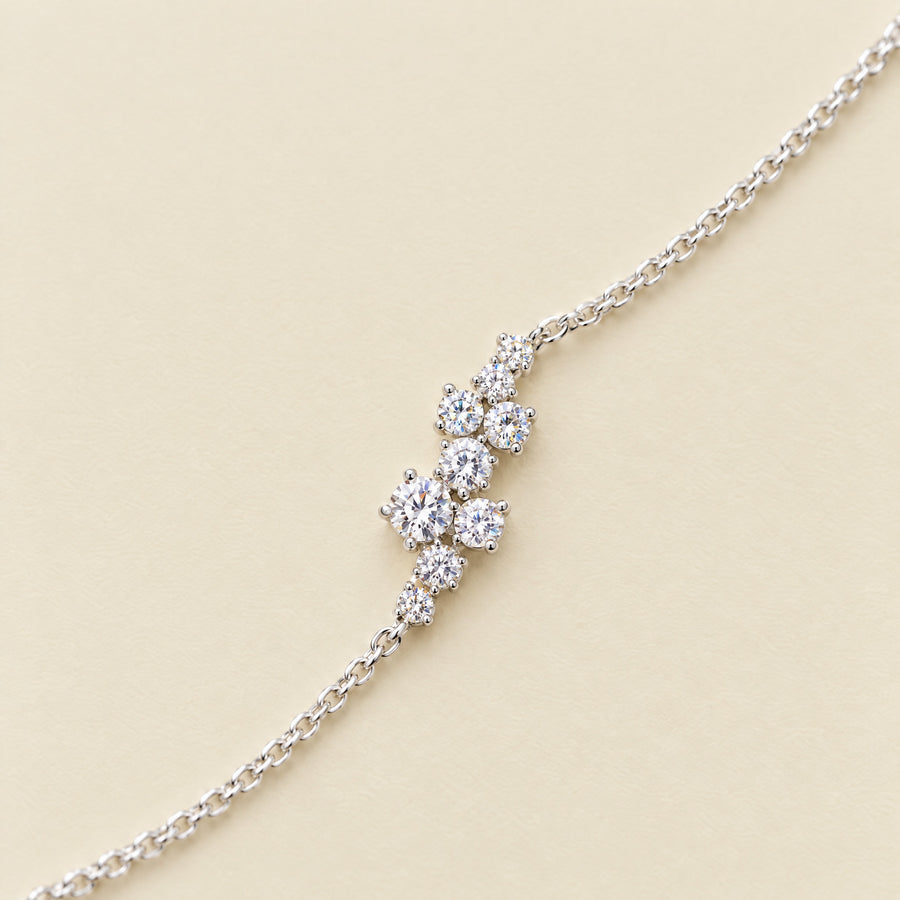 Close view of the nine-stone moissanite cluster on the fine sterling chain, on a cream ground.