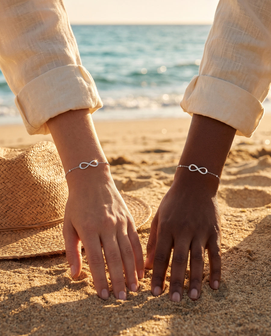 A Mediterranean beach at golden hour: her hand resting on warm sand beside a straw hat, soft shadows.