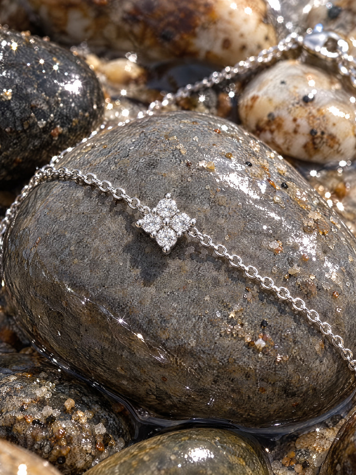 Macro of one four-point star: four round brilliant moissanites in prongs on the rhodium-finished sterling chain.