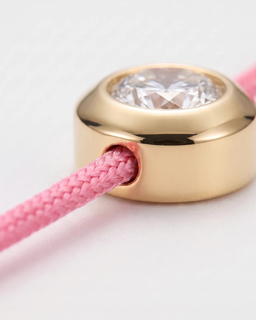 Macro photograph of the gold-plated bezel with the braided cord passing through it