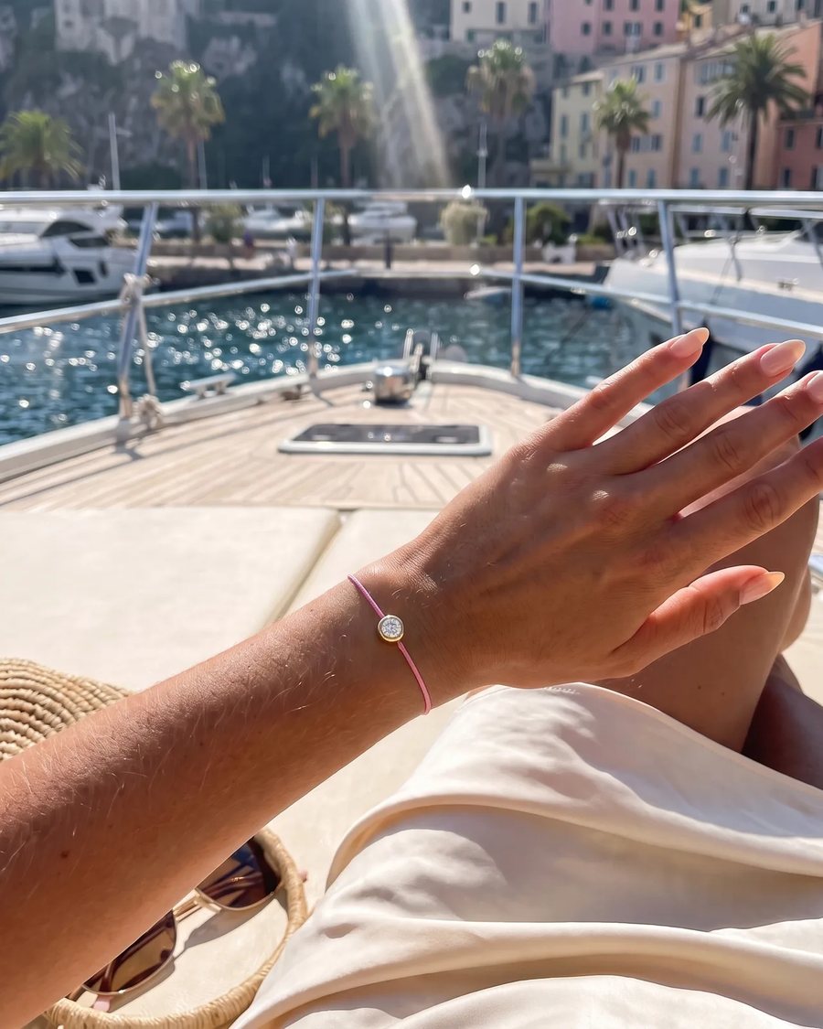 The Pink bracelet worn on a boat deck